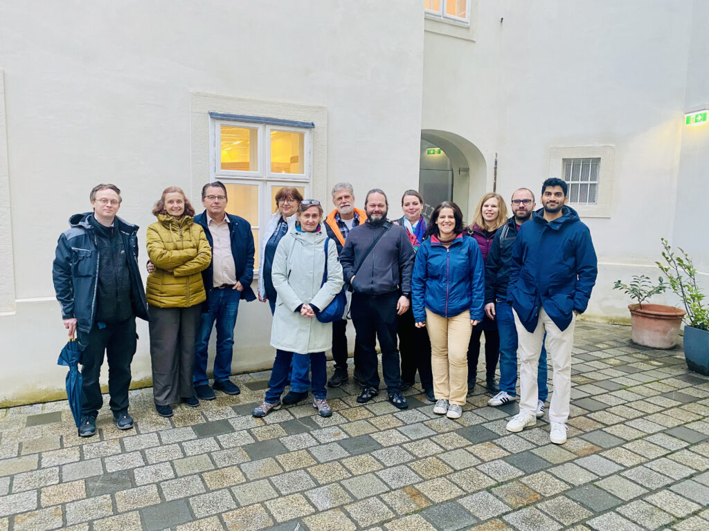 Gruppenbild der Samariterbund-Exkursionsgruppe im Innenhof des Narrenturm Wien. Abgebildet sind zwölf Personen in Winterjacken vor einer weißen Wand.